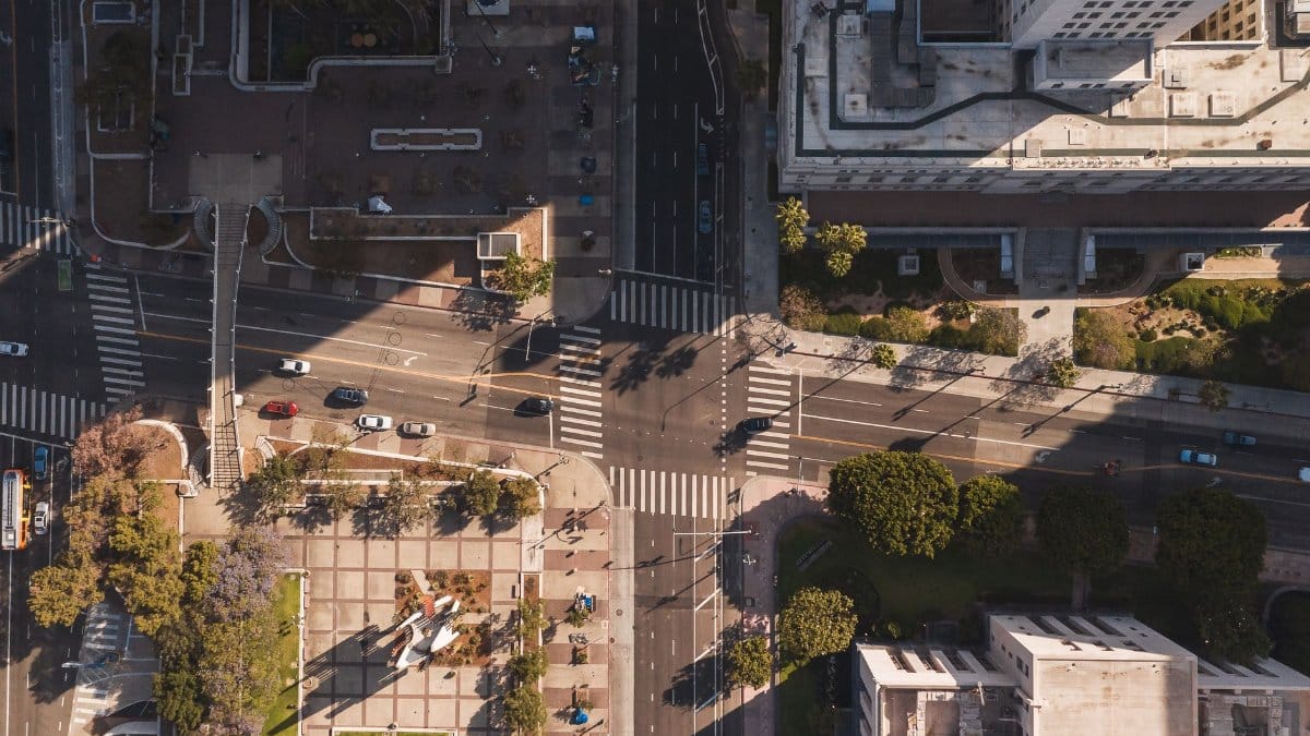 Stunning aerial shot of a city intersection captured during summer, showcasing urban life from above.