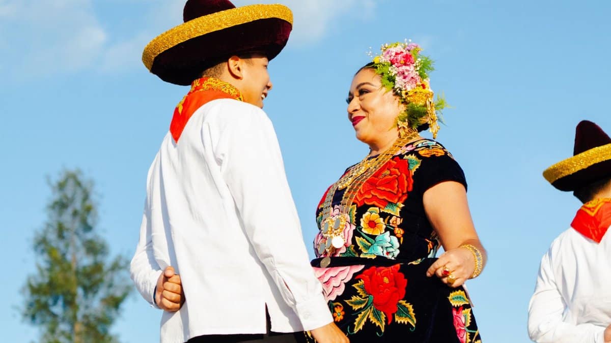 A cultural scene of dancers in traditional Mexican attire during a festive event in Oaxaca, Mexico.