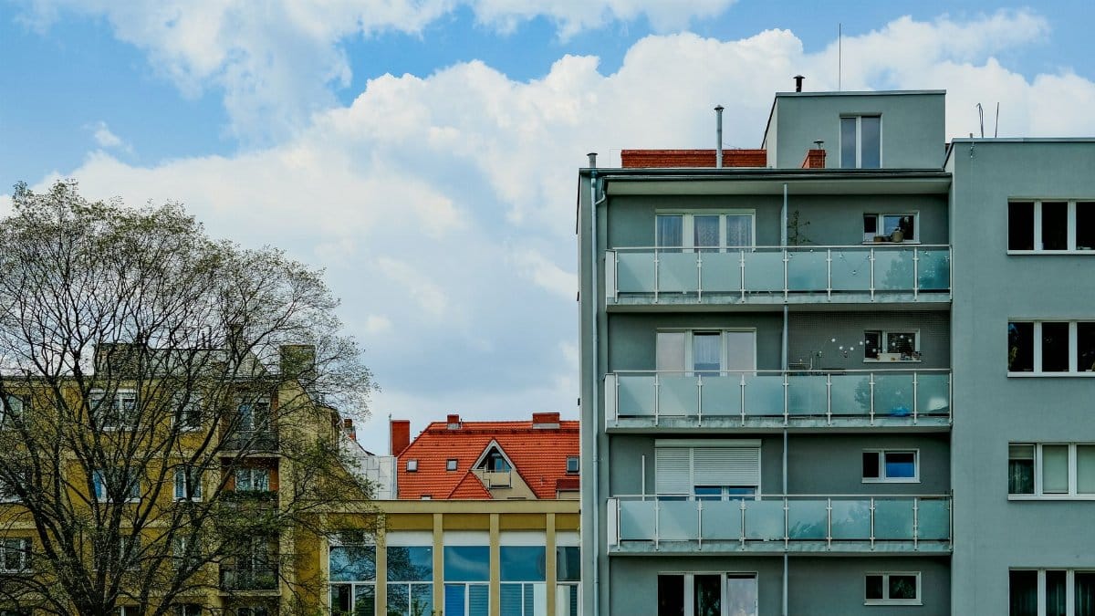City apartment buildings with diverse architectural styles under a clear blue sky.