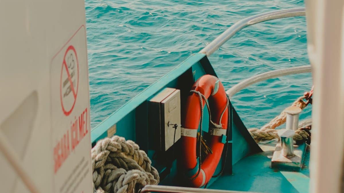 Close-up of a life buoy and ropes on a boat at sea, highlighting safety measures.