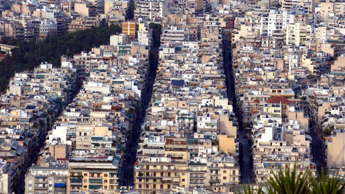 A dense arrangement of urban buildings captured from above, depicting city life.