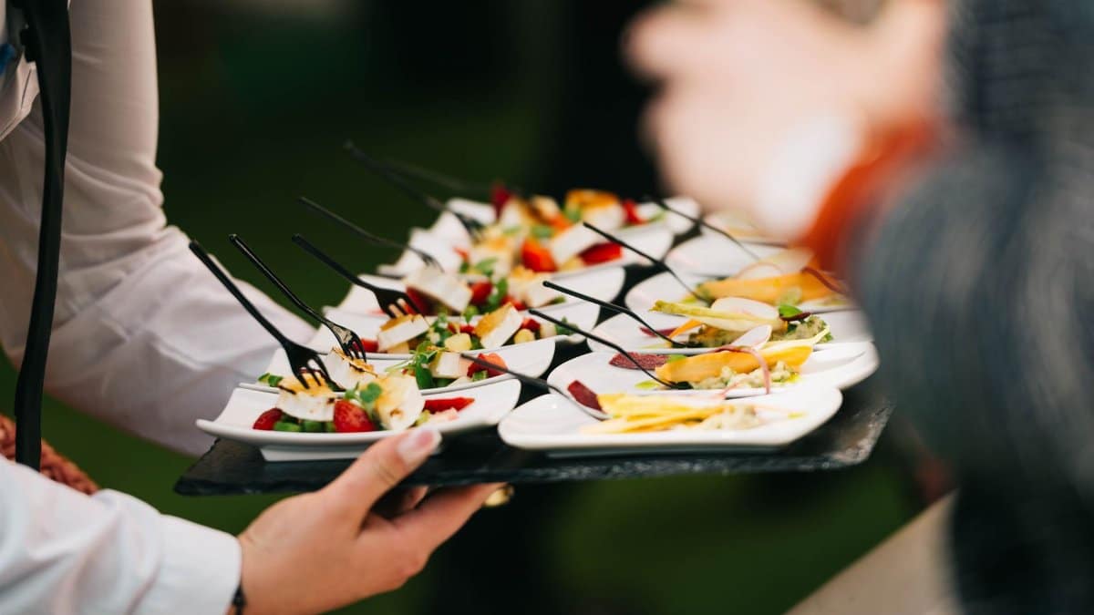 Elegant catering presentation with gourmet appetizers on a tray at a social event.