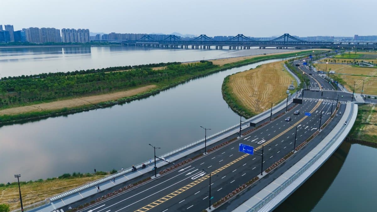Aerial perspective of Qiantang River and modern bridge in Hangzhou, showcasing urban architecture and transportation infrastructure.