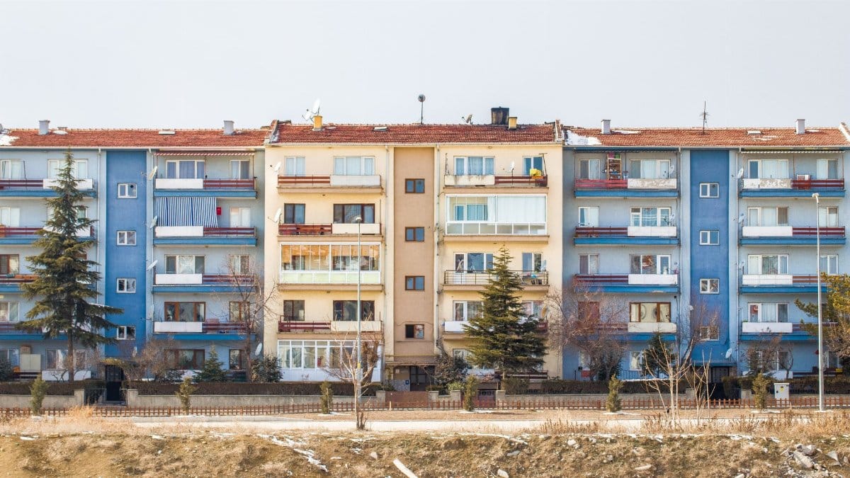 Colorful apartment blocks with balconies in a winter setting, showcasing urban architecture.