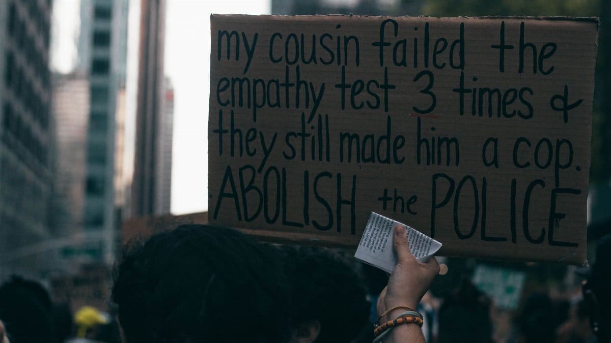 Candid shot of a protester holding a sign demanding police reform during a city demonstration.
