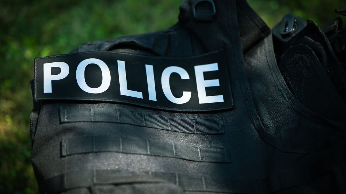 Detailed shot of a police vest lying outdoors, highlighting law enforcement gear.