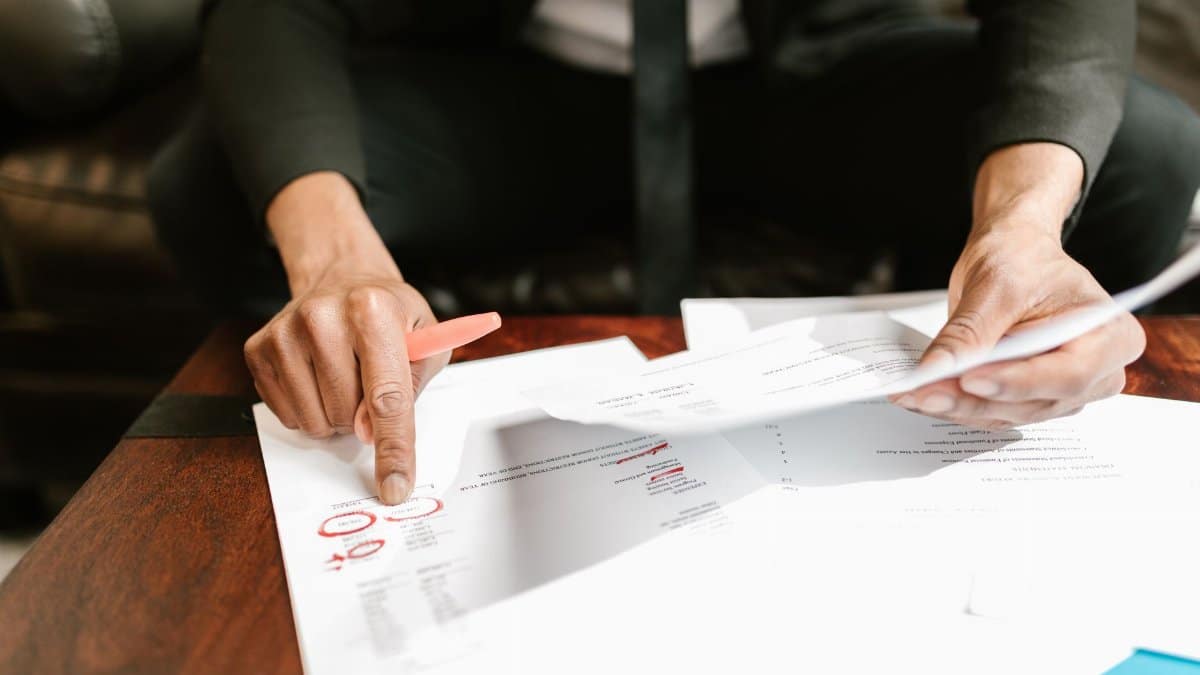 A businessman analyzing financial documents with important data and figures on a desk, ideal for business analytics and accounting themes.