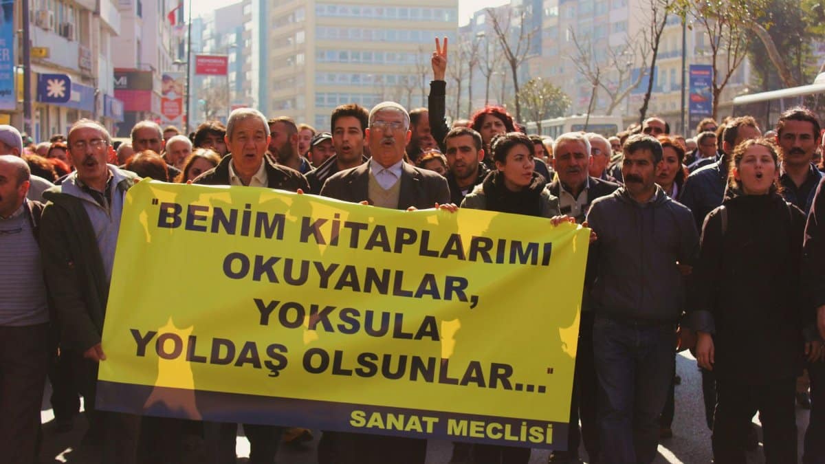 A protest crowd holding a banner in the streets, expressing solidarity for a cause.