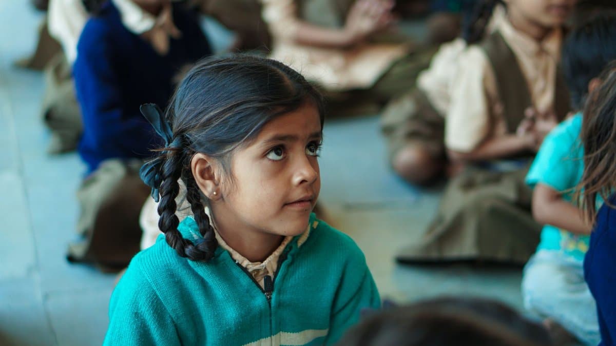 Young girl in a classroom, focusing attentively on the lesson, embodying education and curiosity.