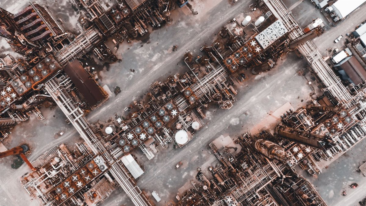 Drone shot capturing the intricate layout of a large industrial factory from above.