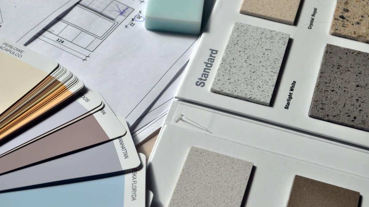 Color palette and material samples for interior renovation projects on a blueprint.