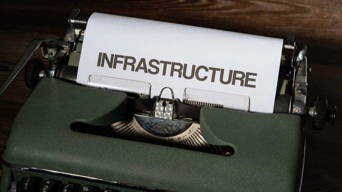 Close-up of a vintage typewriter with 'infrastructure' typed on paper.