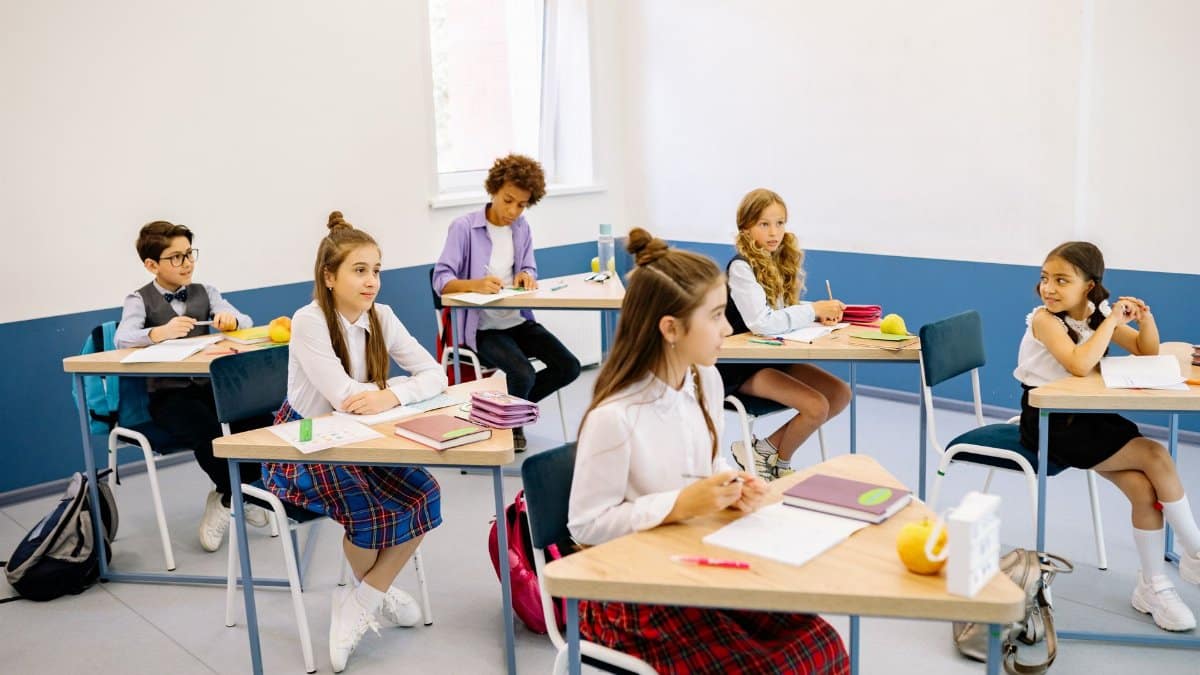 Students learning in a bright, diverse classroom setting, engaged and attentive.