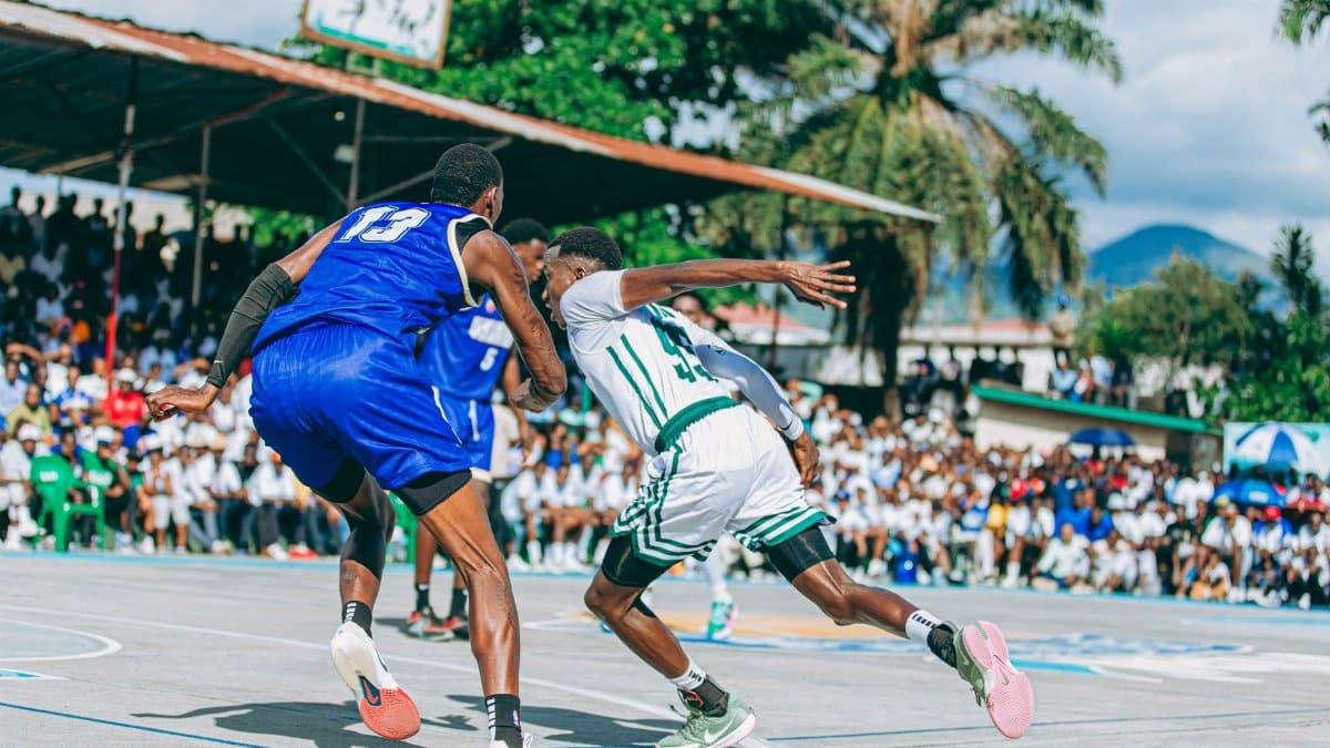 Players compete in an exciting outdoor basketball game with a lively crowd watching.