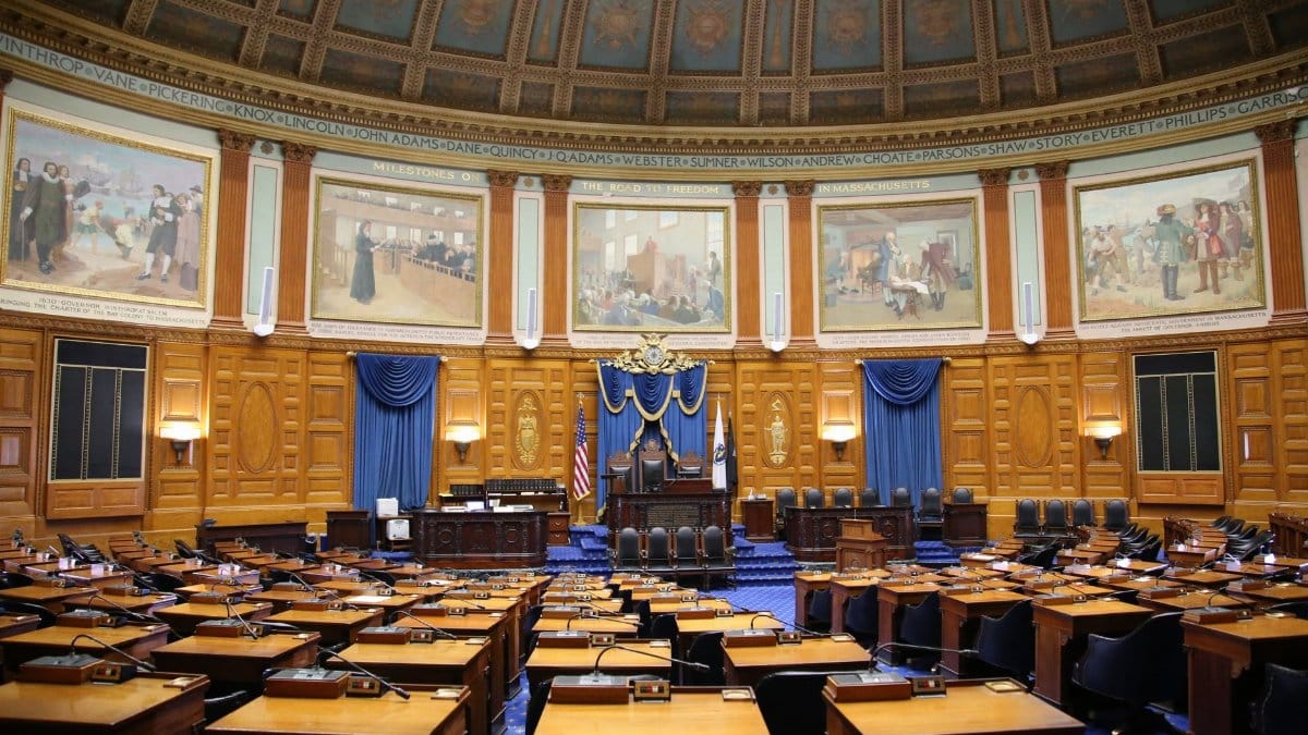 A beautiful view of the Massachusetts State House chamber with elegant decor and empty seating.