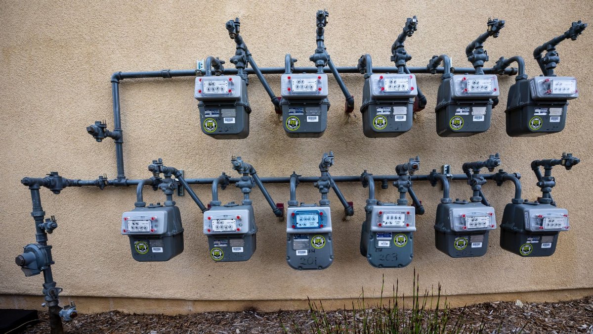 A neat installation of gas meters mounted on an exterior wall in an urban setting.