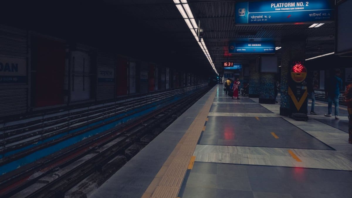 A dimly lit metro station platform with passengers waiting, showcasing urban public transportation.