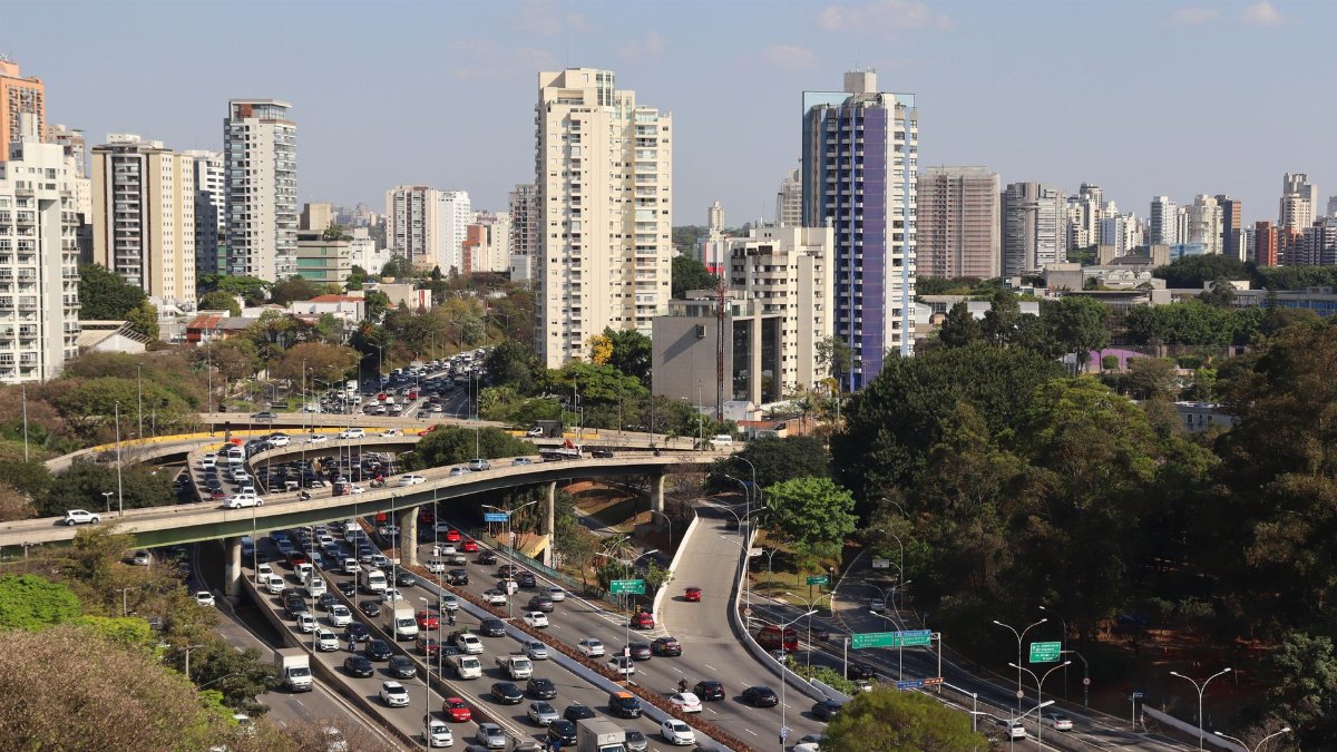 Aerial view of a bustling expressway and urban skyline in São Paulo, Brazil.