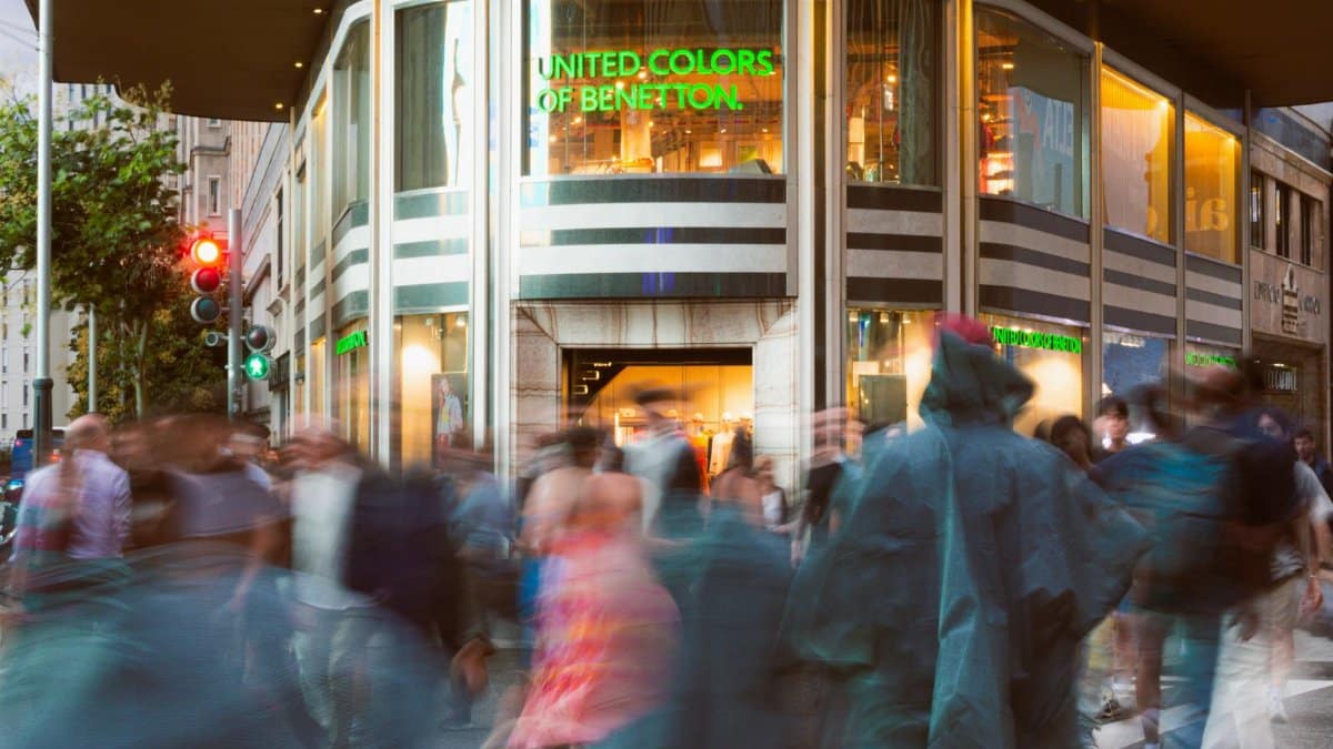 A dynamic urban street scene in Madrid with blurred motion of people outside United Colors of Benetton.