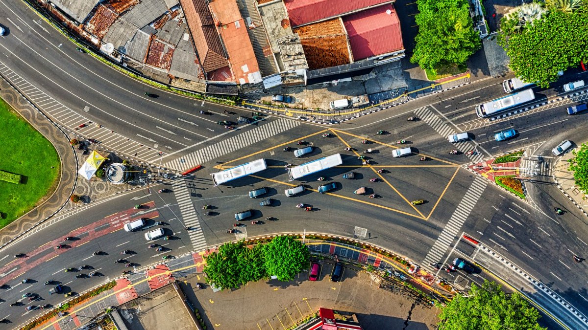 Dynamic aerial view of a busy urban intersection in Jakarta, showcasing city traffic and infrastructure.