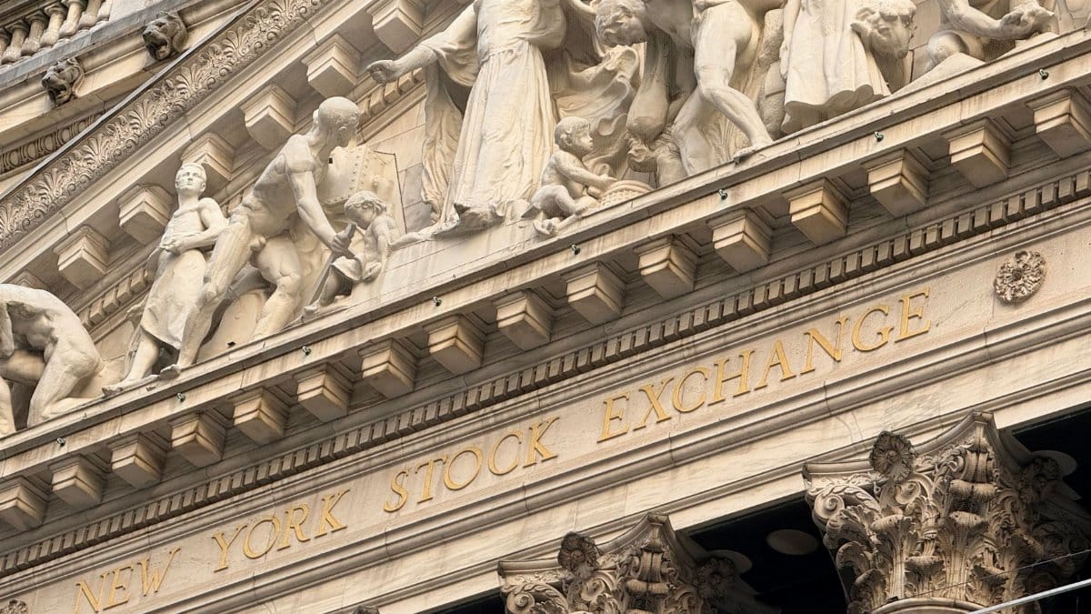 Ornate façade of the New York Stock Exchange featuring intricate stone sculptures during daylight.