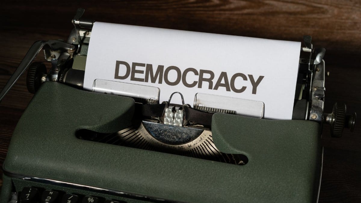 Close-up of a vintage typewriter with the word 'Democracy' on paper, emphasizing freedom and expression.