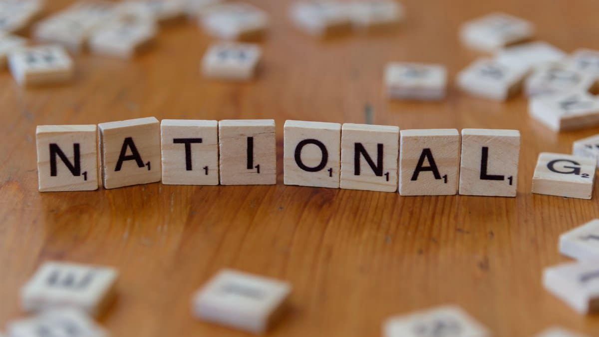 Wooden letter tiles spell 'National' on a wooden table.