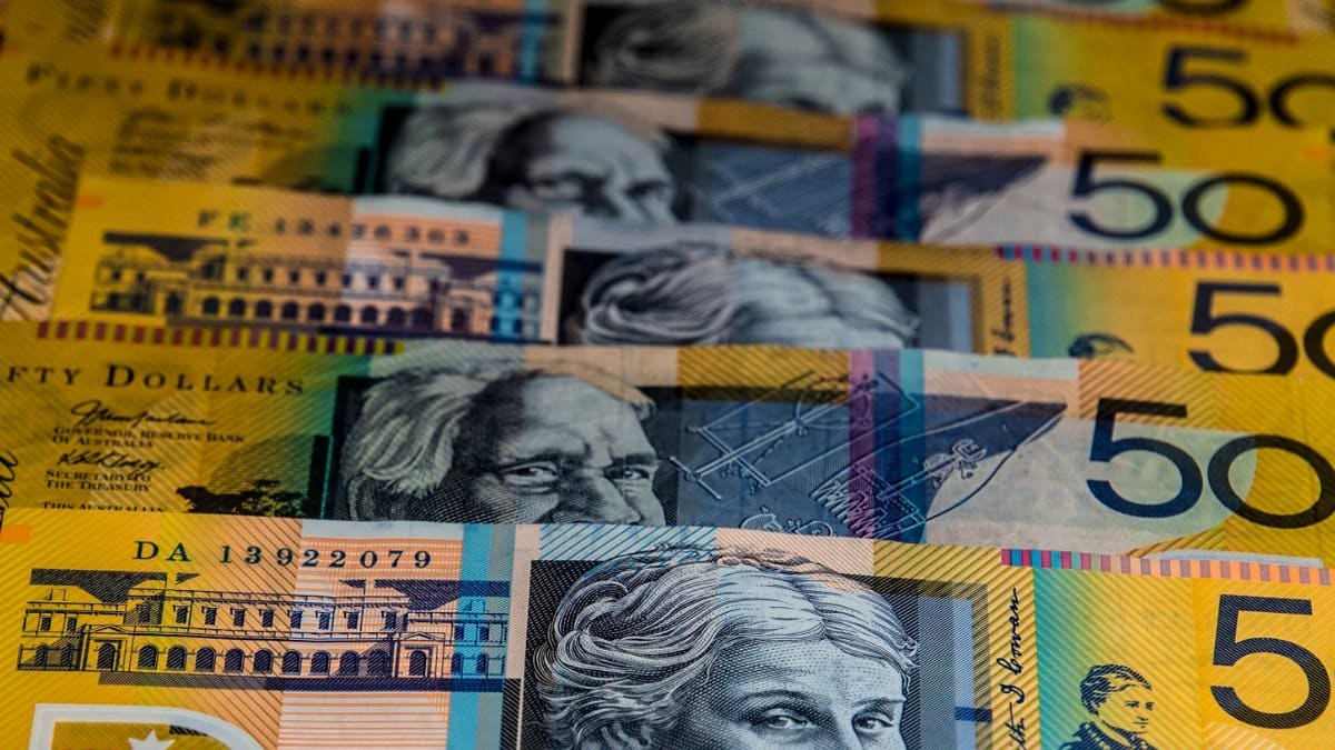 Close-up view of Australian $50 bills arranged in a pattern. Vibrant colors and detailed imagery highlight currency features.