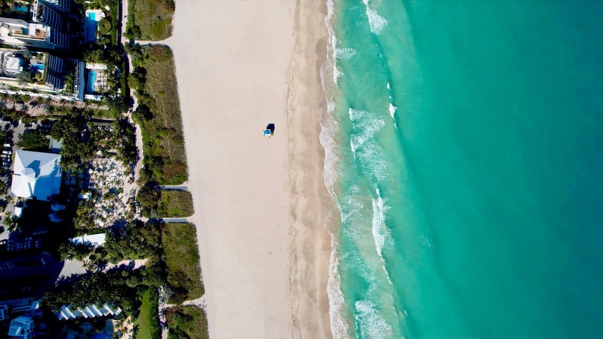 Stunning aerial view of Miami Beach's coastline, showcasing turquoise waters and sandy shorelines.