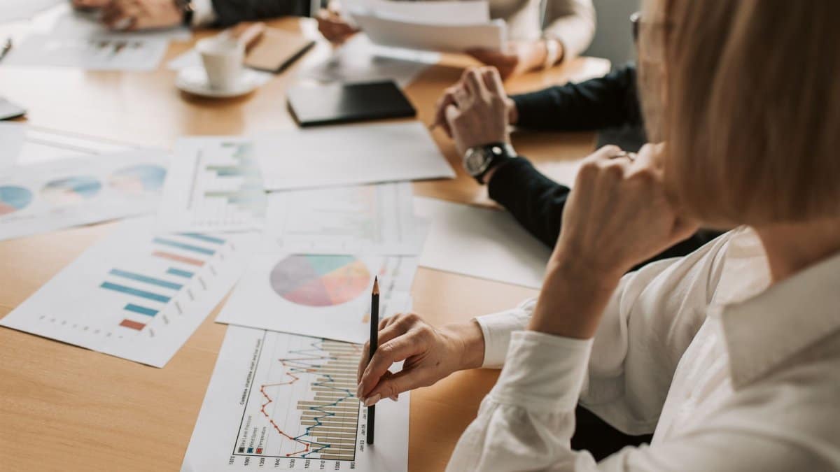 Business professionals reviewing charts and graphs during a meeting in office setting.