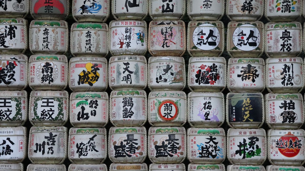 A collection of traditional Japanese sake barrels with colorful kanji designs in Tokyo, Japan.