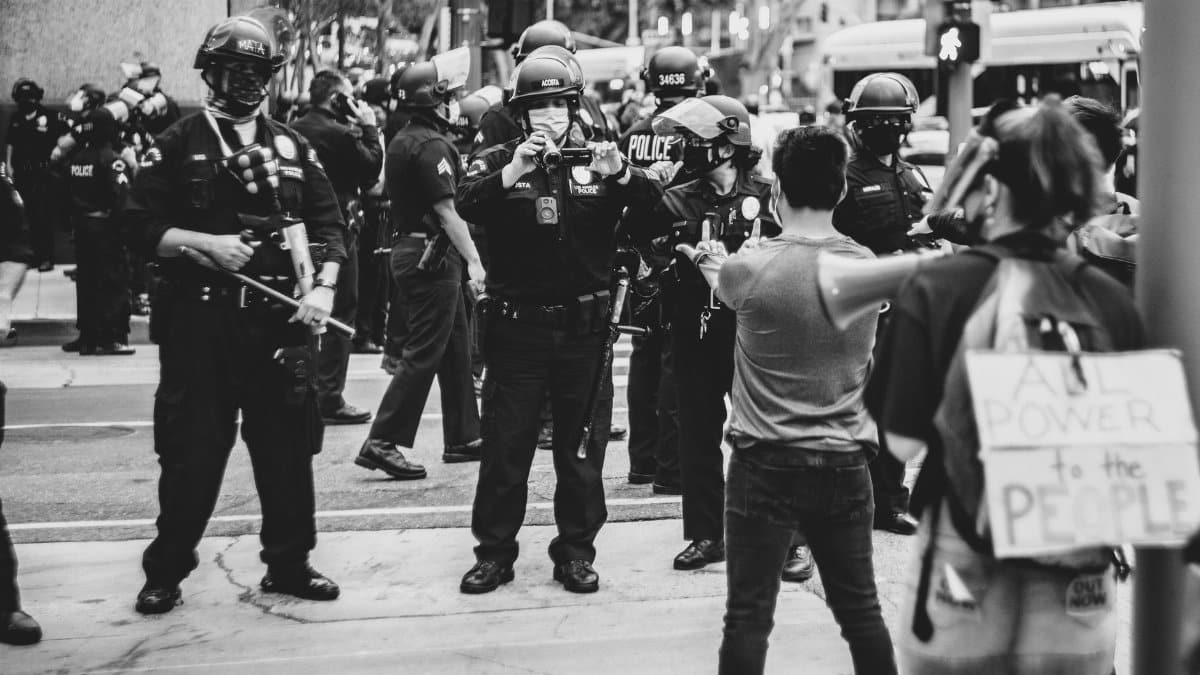Black and white image of a protest with police and demonstrators in Los Angeles.