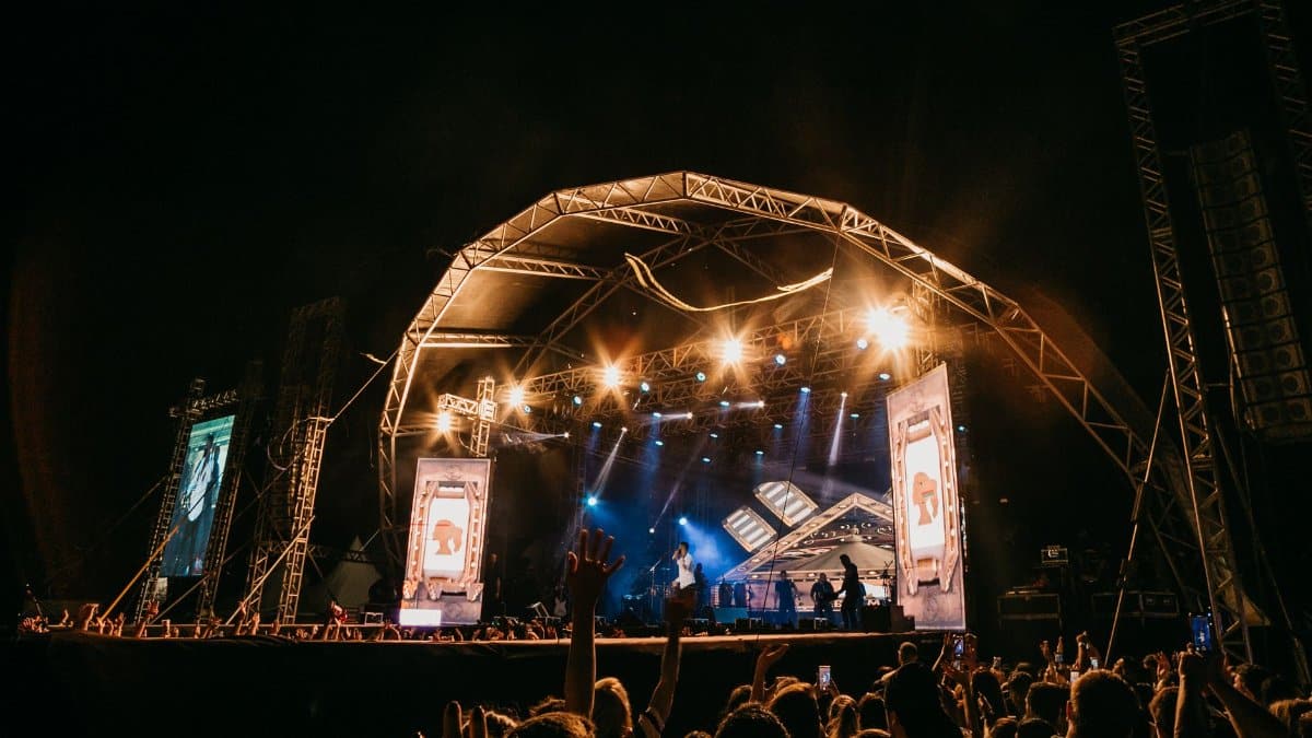 Vibrant live performance with crowd at an outdoor concert stage.