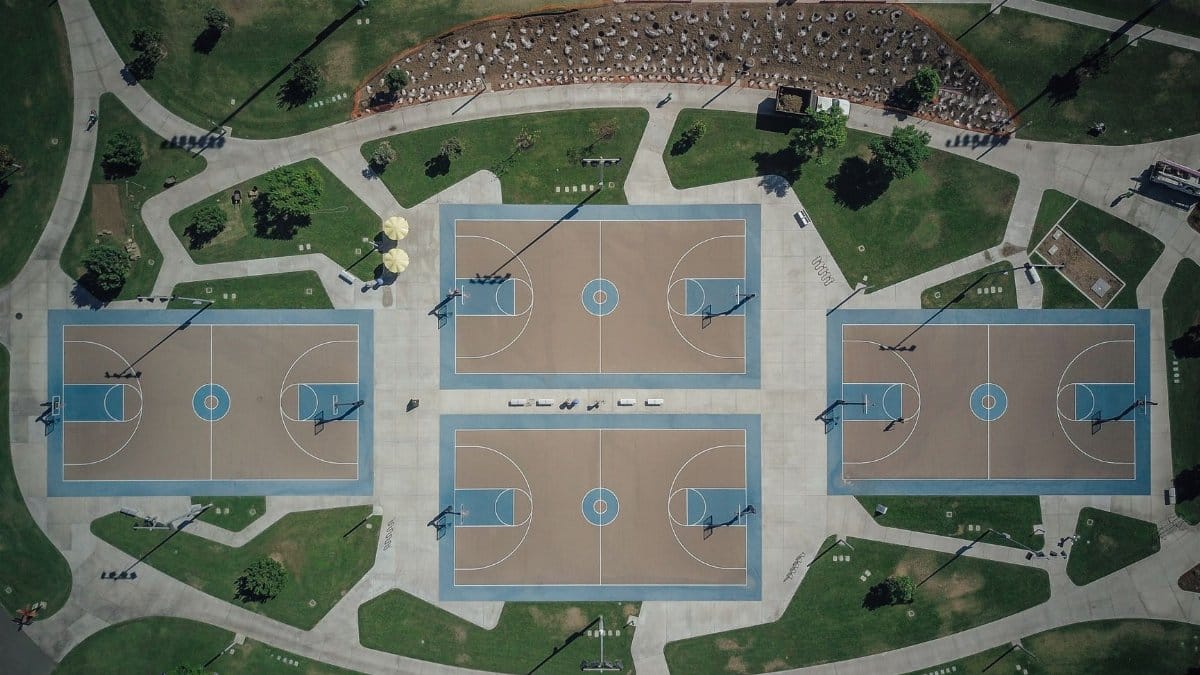 Aerial shot of outdoor basketball courts in a recreational park setting.