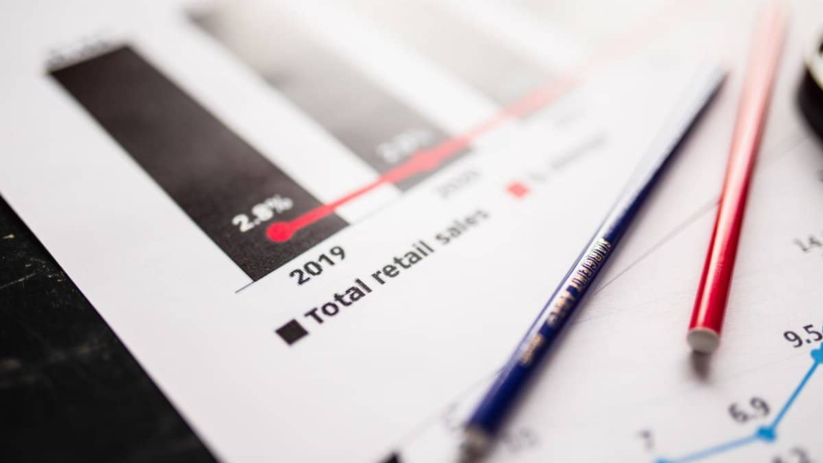 Detail view of retail sales chart and pencils on desk, showcasing data analysis.