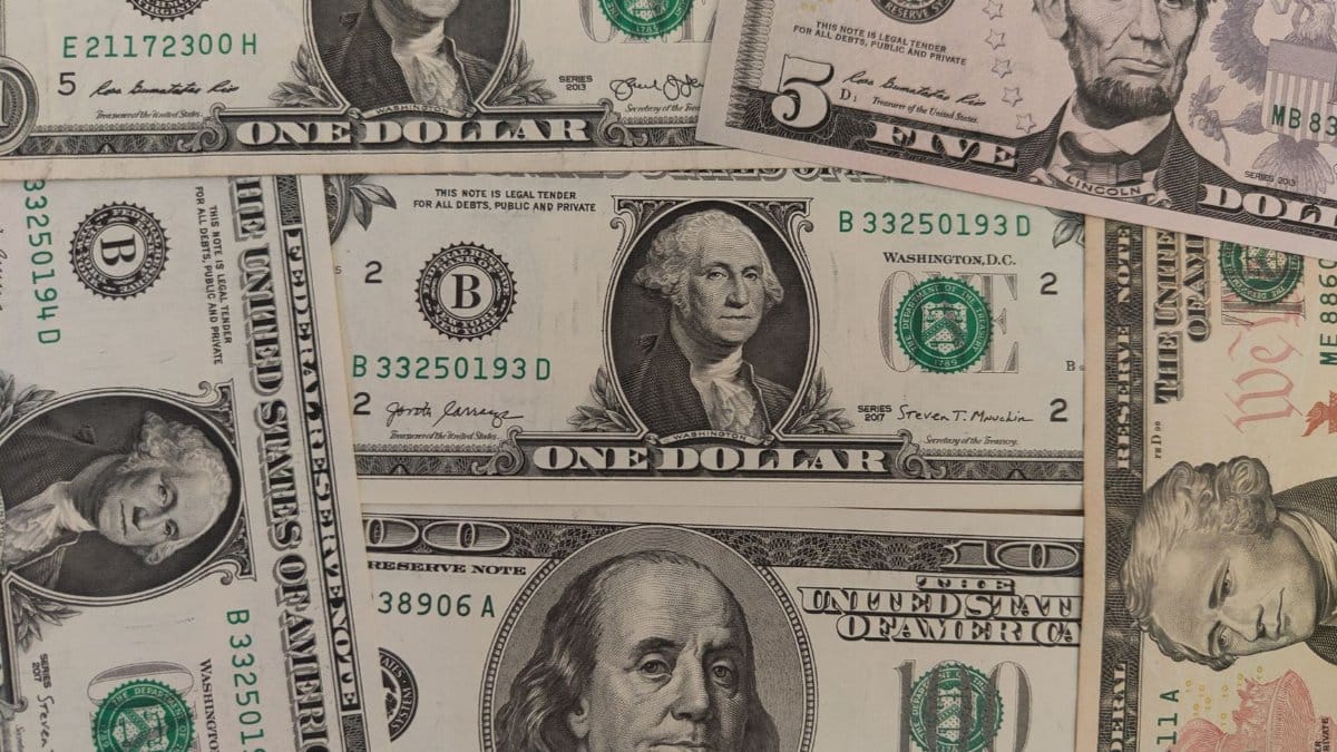 Close-up image showing a mix of U.S. dollar bills including $1, $5, and $10 bills.
