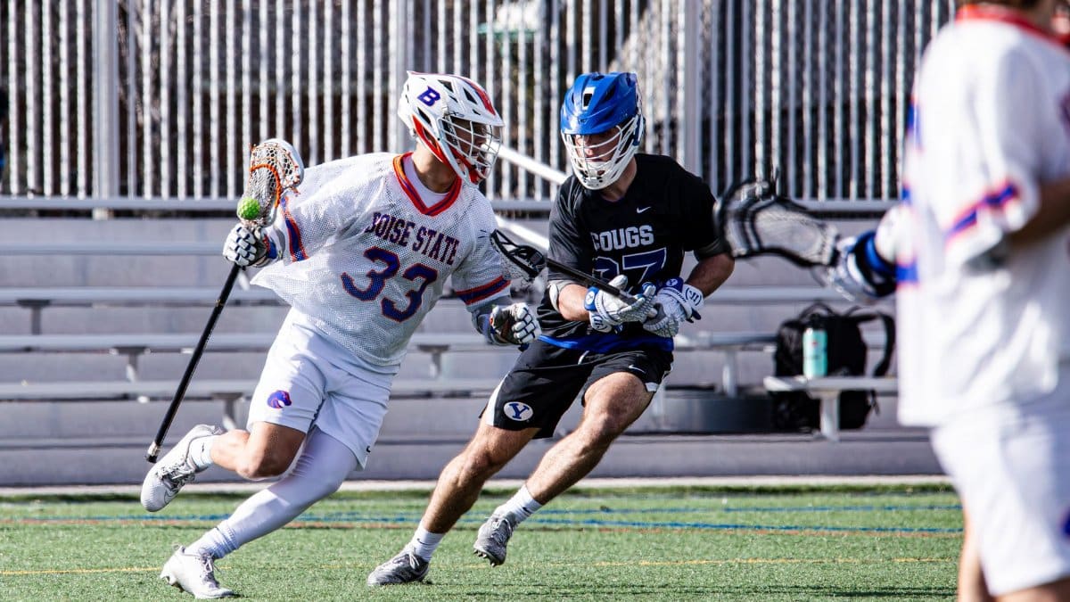 Dynamic action captured during a university lacrosse game in Provo, featuring two players competing.