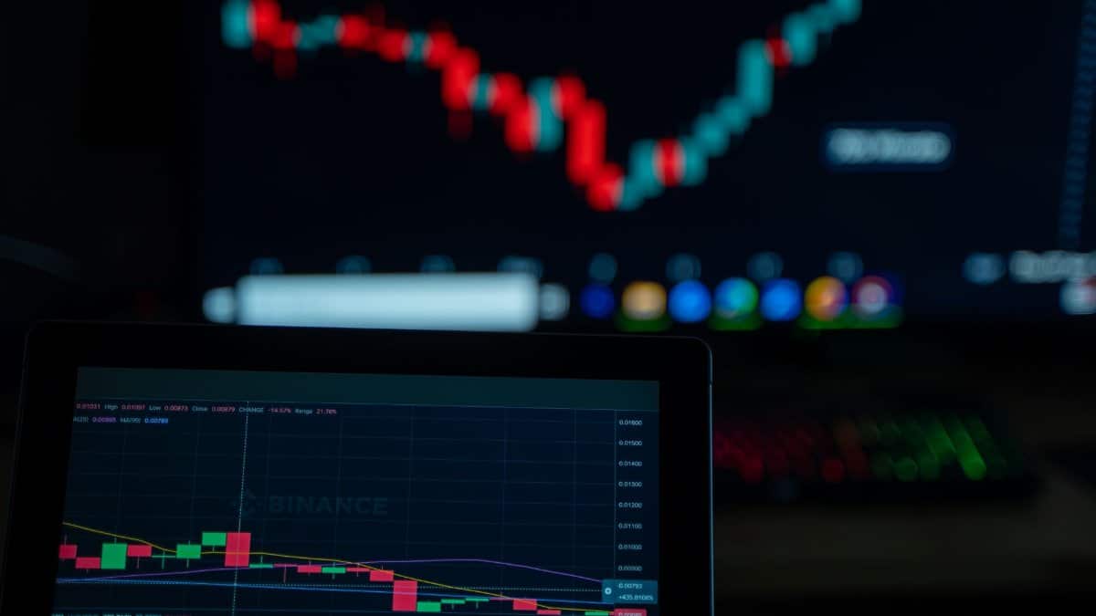 Close-up of cryptocurrency market charts on multiple screens showcasing trading data and trends.