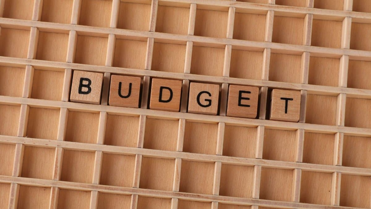 Wooden Scrabble tiles spelling 'budget' on a textured wooden grid, symbolizing financial planning.