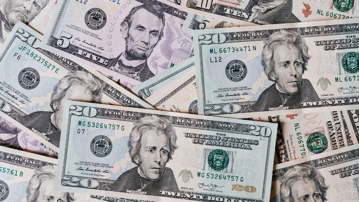 Top view of different types and colors American dollars placed together on each other