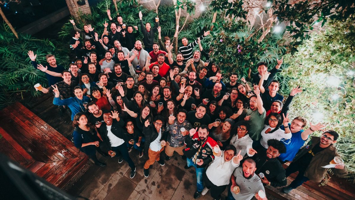 A large group of joyful people posing under string lights in a garden setting. Perfect for joyful and community themes.