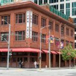 A red brick historic building named Town Hall in downtown San Francisco surrounded by modern architecture.