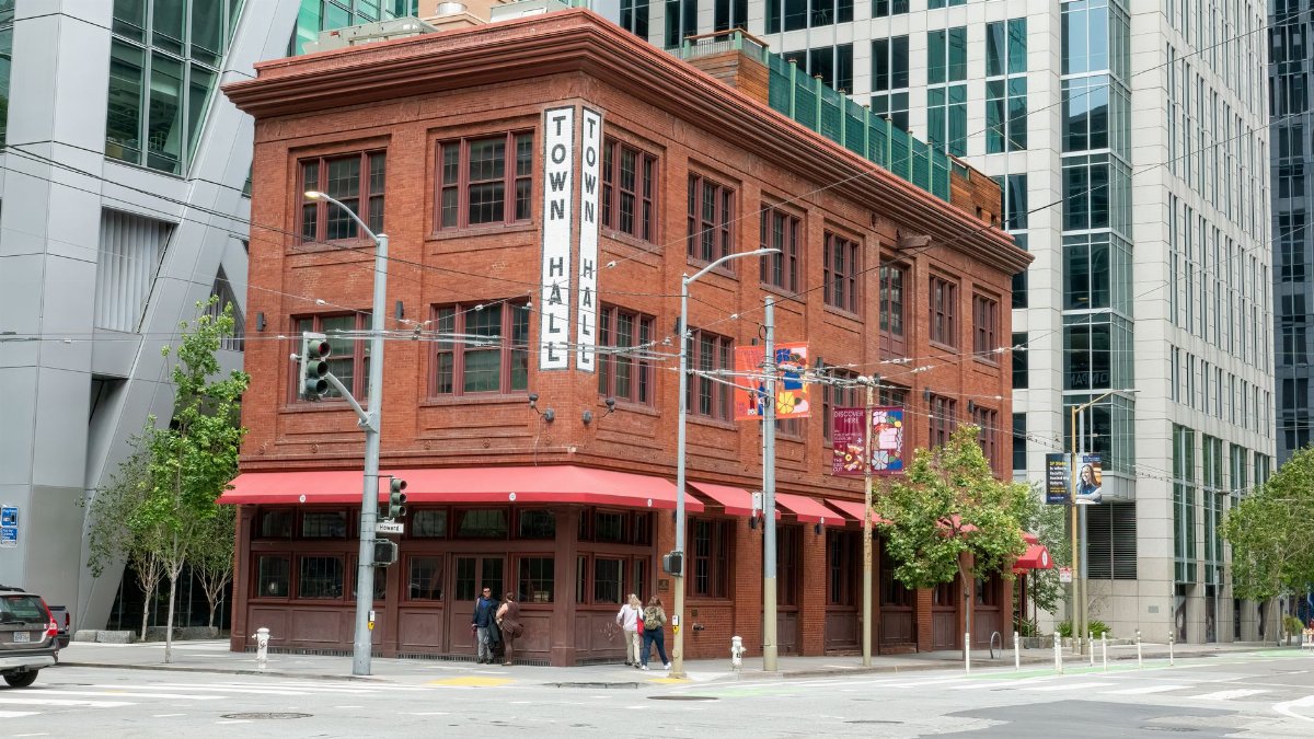 A red brick historic building named Town Hall in downtown San Francisco surrounded by modern architecture.