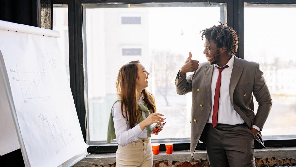 Two business professionals share a moment of success during a meeting, showcasing teamwork and collaboration.