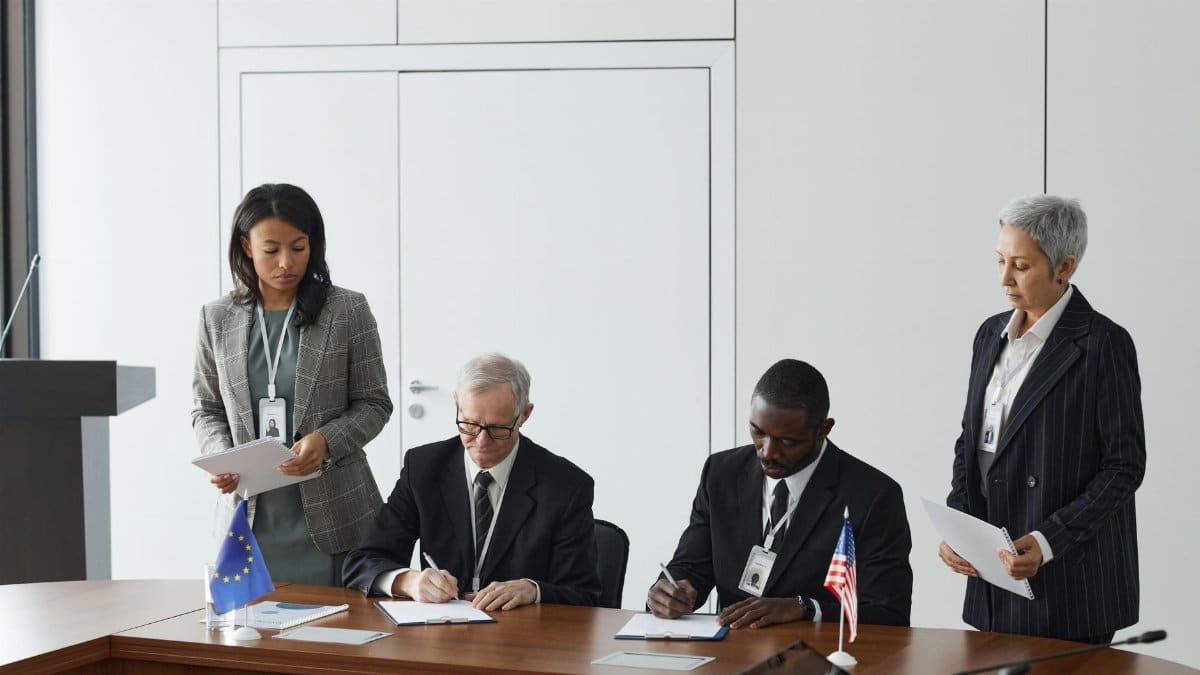 Business leaders signing a significant agreement in a conference room setting.