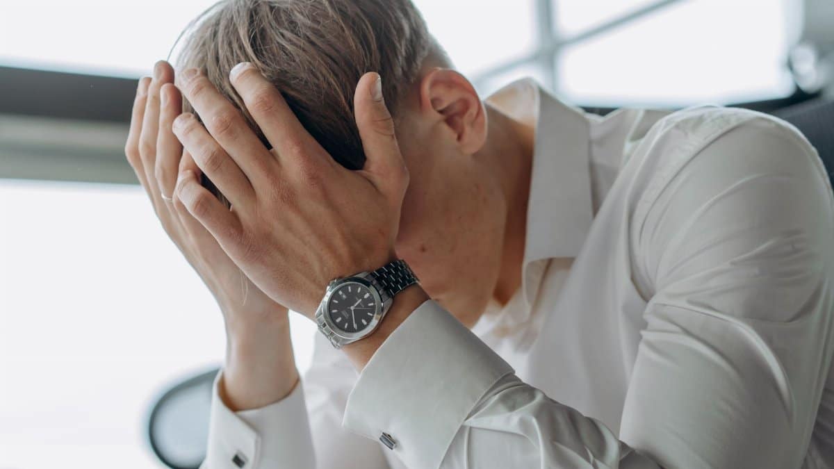 A business professional showing stress and fatigue with head in hands.