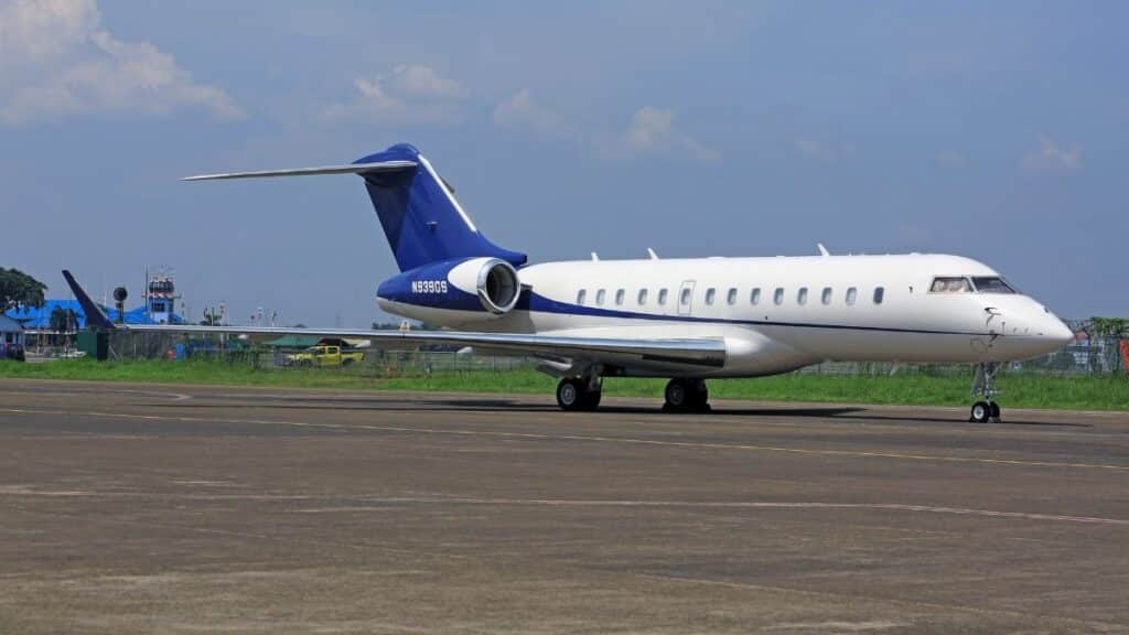 A sleek private jet parked on the airport tarmac under a clear blue sky, conveying luxury and travel.