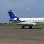 A sleek private jet parked on the airport tarmac under a clear blue sky, conveying luxury and travel.