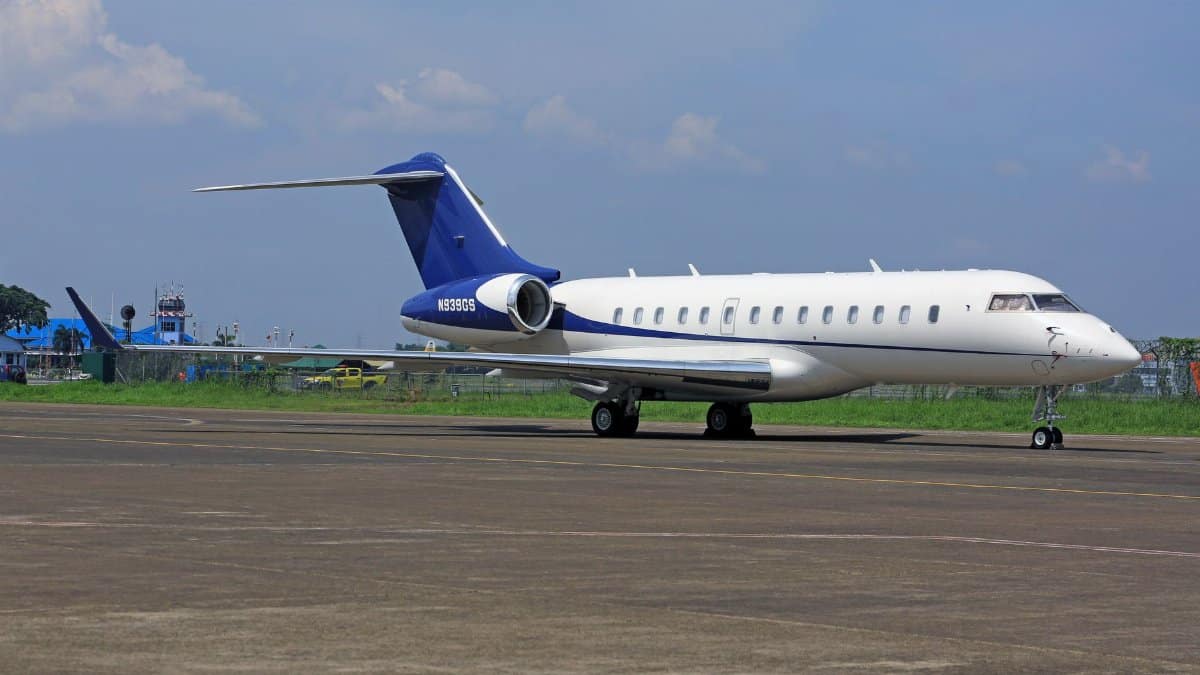 A sleek private jet parked on the airport tarmac under a clear blue sky, conveying luxury and travel.
