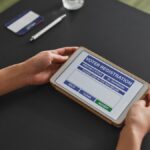 A person using a tablet for voter registration, highlighting digital voting processes.